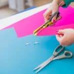 Woman's hand cutting colorful papers