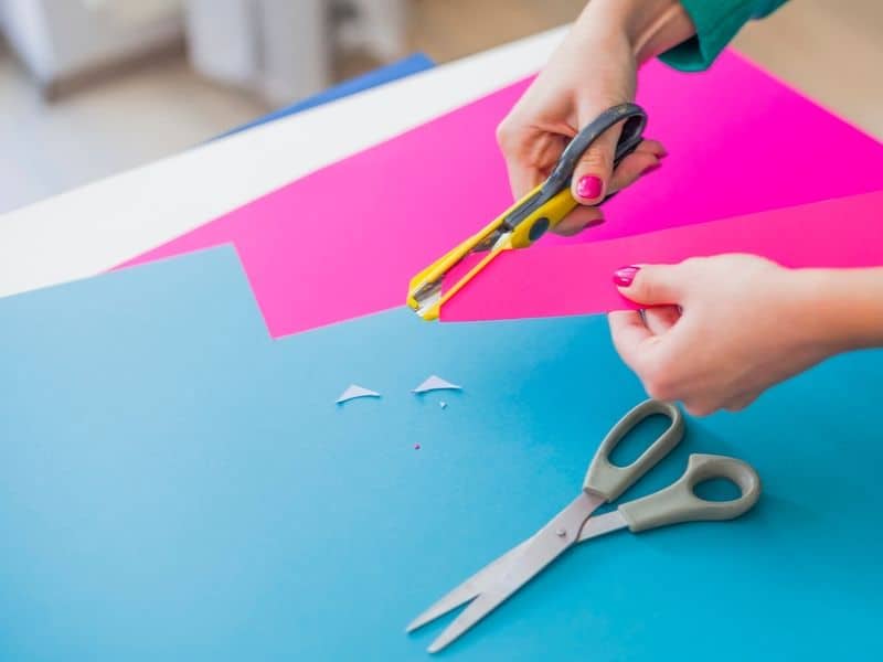 Woman's hand cutting colorful papers